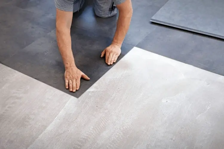 man installing linoleum flooring