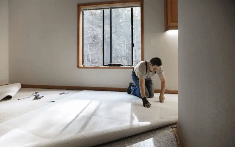 man straightening carpet
