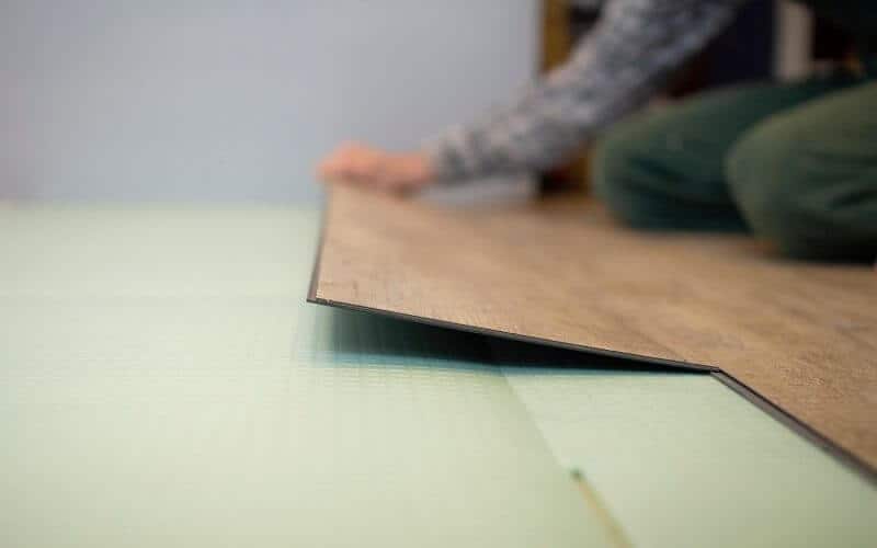 man installing vinyl floor tile
