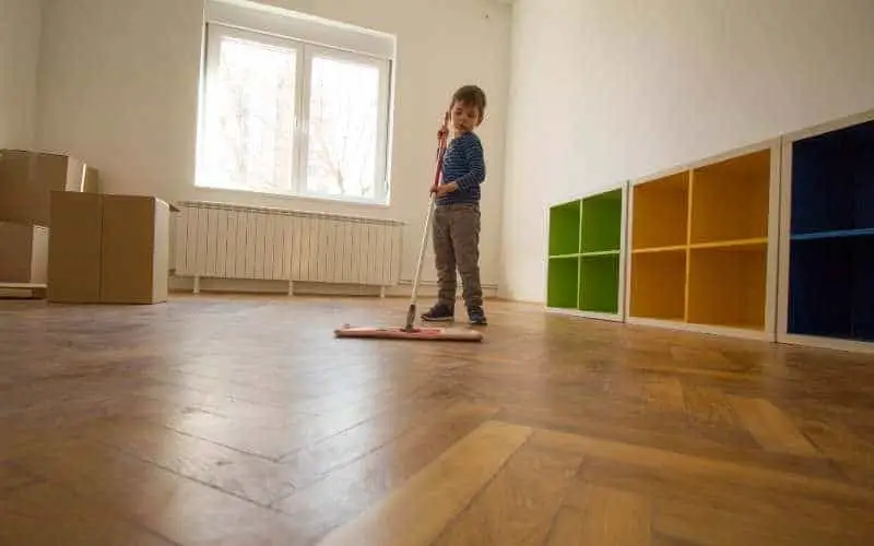 little boy cleaning wood floor